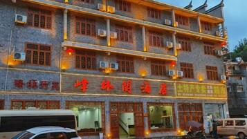 A multi-story building with a traditional architectural style, featuring a prominent sign with Chinese characters.