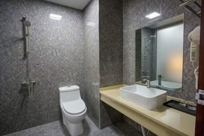 A bathroom with a toilet, shower, sink, and mirror. - Fenglinge Hotel (Zhangjiajie)