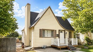 Une maison de plain-pied avec un porche à l’avant, une cheminée et une boîte aux lettres.