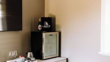Eine Minibar mit einer Flasche Last St. Beckworth Wein, einem Glasbehälter und einer Kaffeemaschine.