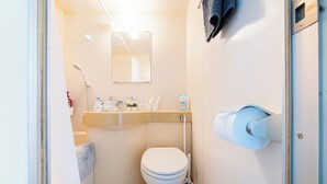 Ein kleines Badezimmer mit Toilette, Waschbecken mit Spiegel darüber und Handtuchhalter.