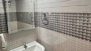 A bathroom with a white sink, a mirror, and a shower. - LUXESTYLE (Adoor)