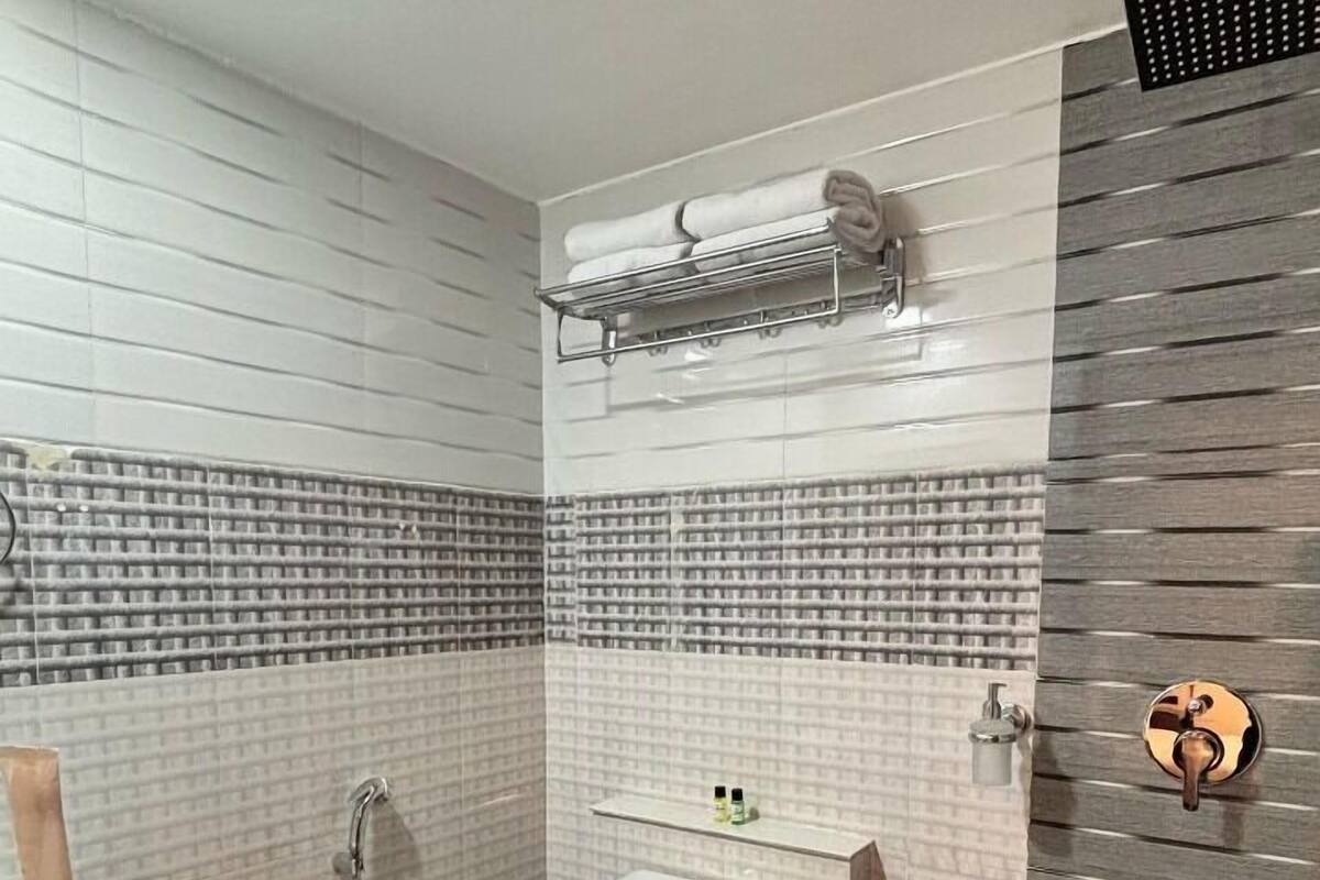 A bathroom with a toilet, sink, and towel rack.