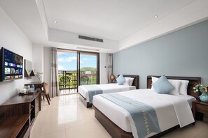 Une chambre d’hôtel avec deux lits, un bureau et un balcon offrant une vue.
