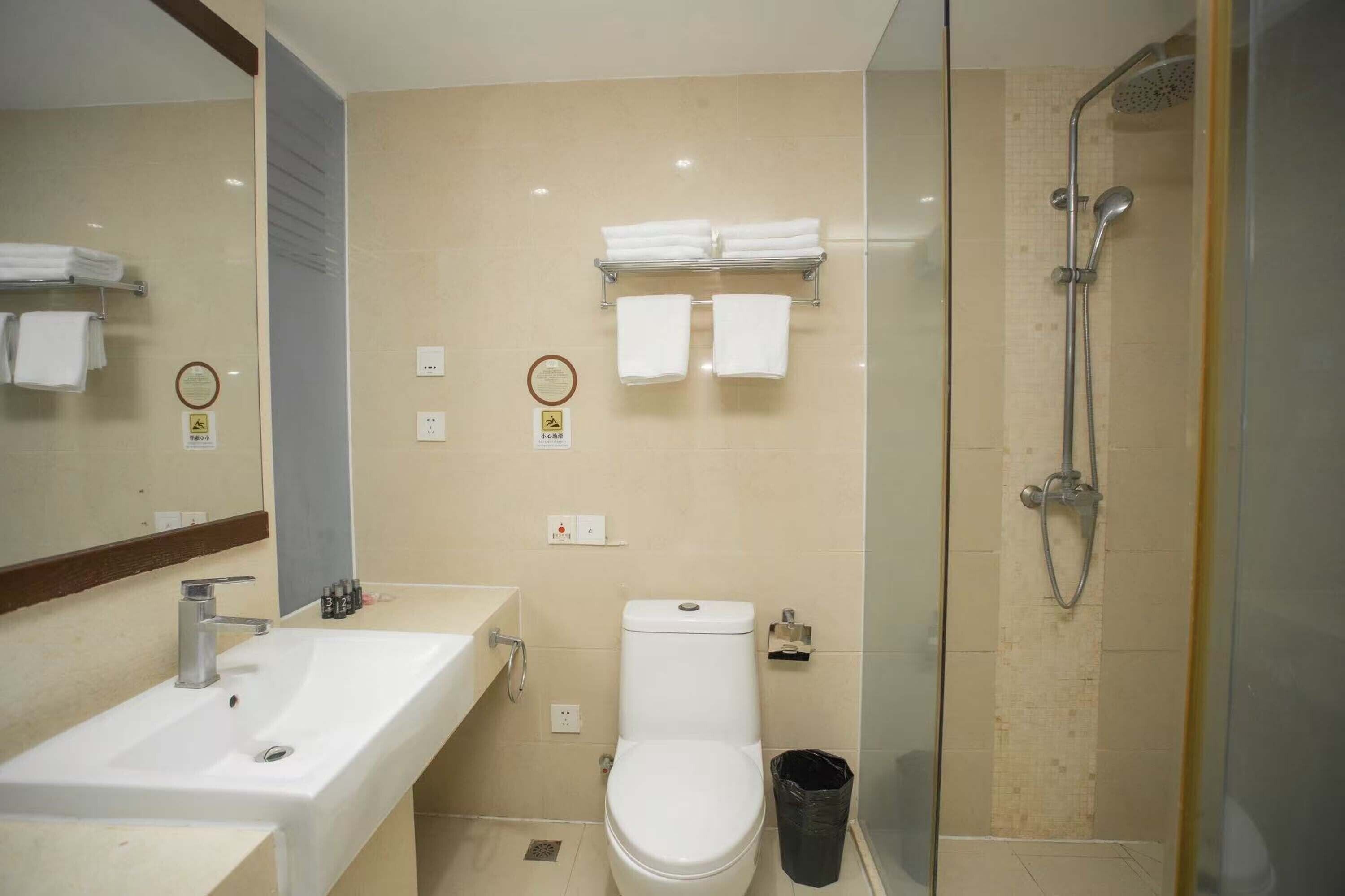 Une salle de bain moderne avec un lavabo, des toilettes et une douche à parois de verre.