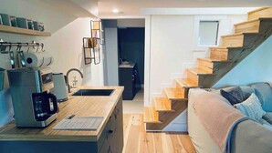 A compact living space with a kitchenette, a bed, and a staircase. - A restful stay in Georgian Bluffs (Georgian Bluffs)