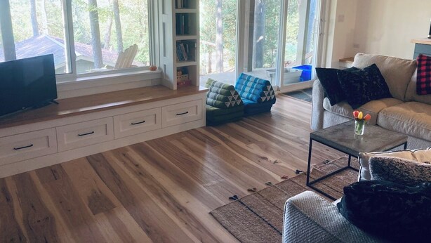 A spacious living room with a large window, built-in bookshelf, and a comfortable seating area. - A restful stay in Georgian Bluffs (Georgian Bluffs)
