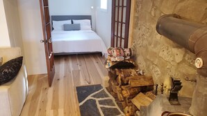 A bedroom with a bed, a wooden chest of drawers, and a fireplace. - A restful stay in Georgian Bluffs (Georgian Bluffs)