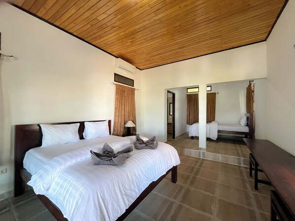 A hotel room with a large bed, a wooden ceiling, and a bathroom visible through an open door. - Bara Cabana Hotel (Bira)