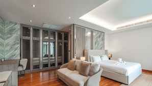Un dormitorio moderno con una cama grande, un sofá y un vestidor.