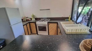 Eine kleine Küche mit Kühlschrank, Herd und Spüle.