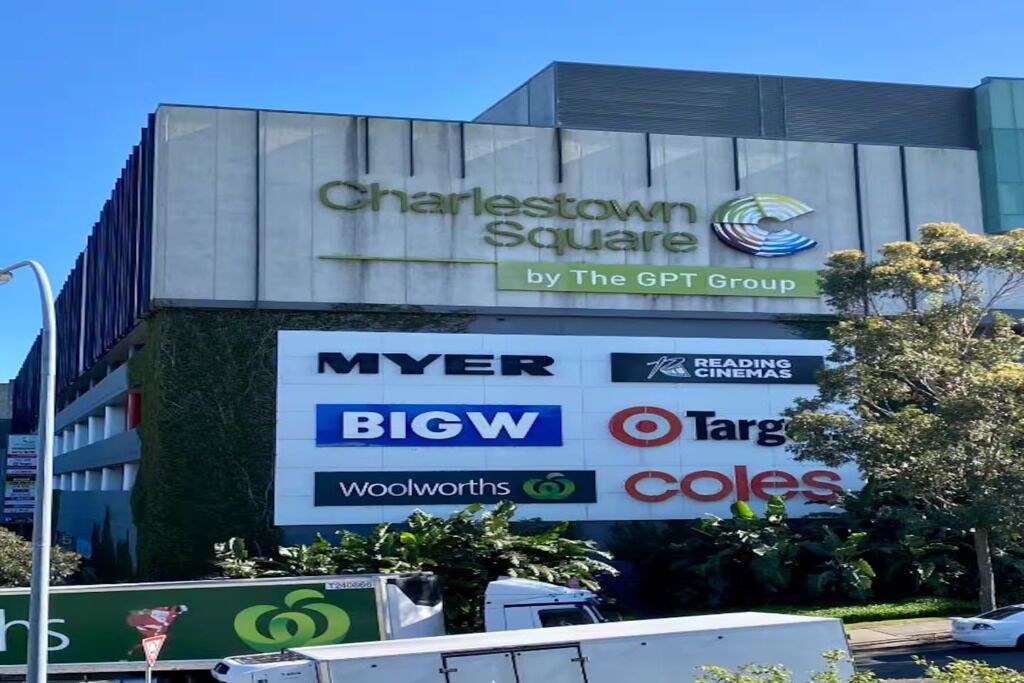 Un edificio con el letrero 'Charlestown Square by The GPT Group' y logotipos de varias tiendas, incluyendo MYER, BIGW, Woolworths, Target y Coles.