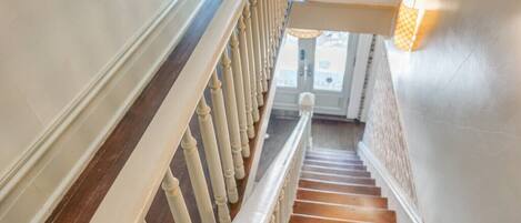 A staircase with white balusters and wooden steps leading to a landing.