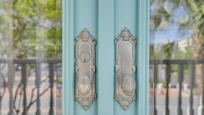 A light blue door with ornate metal handles and a keyhole.