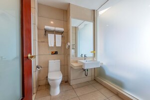 Un baño moderno con inodoro, lavabo y cabina de ducha de vidrio.