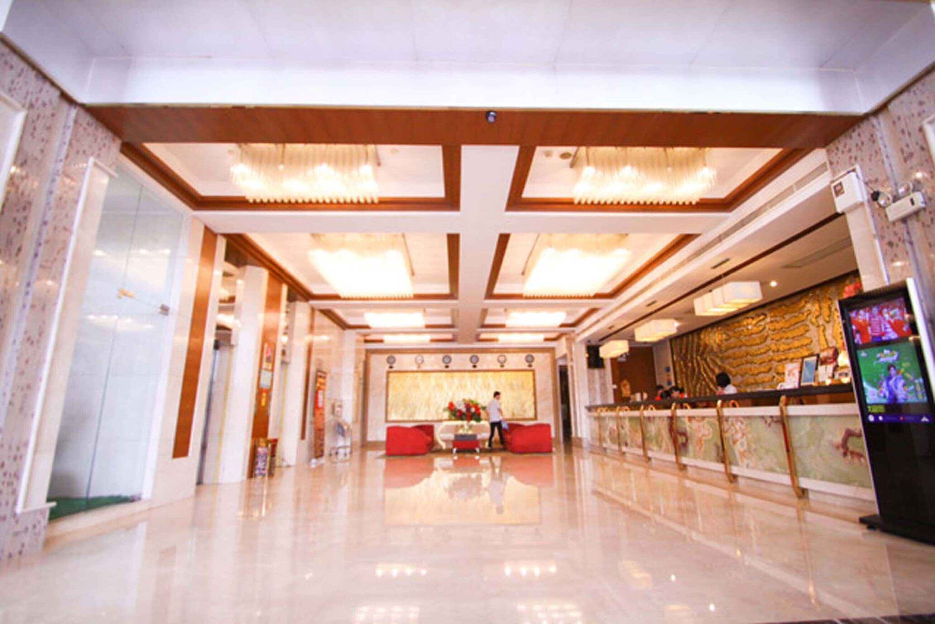A spacious lobby with a high ceiling, a reception desk, and a seating area.