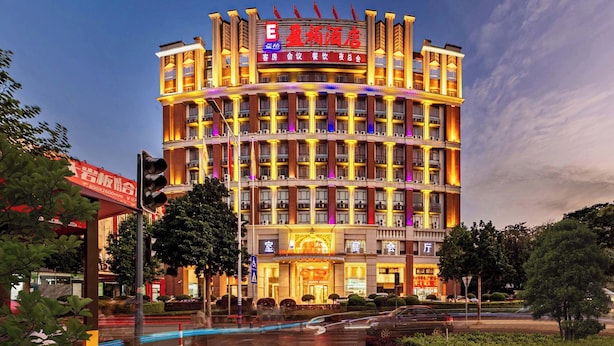 A multi-story hotel with a prominent sign, multiple balconies, and a well-lit facade. - Billions-Earn Hotel (Foshan)