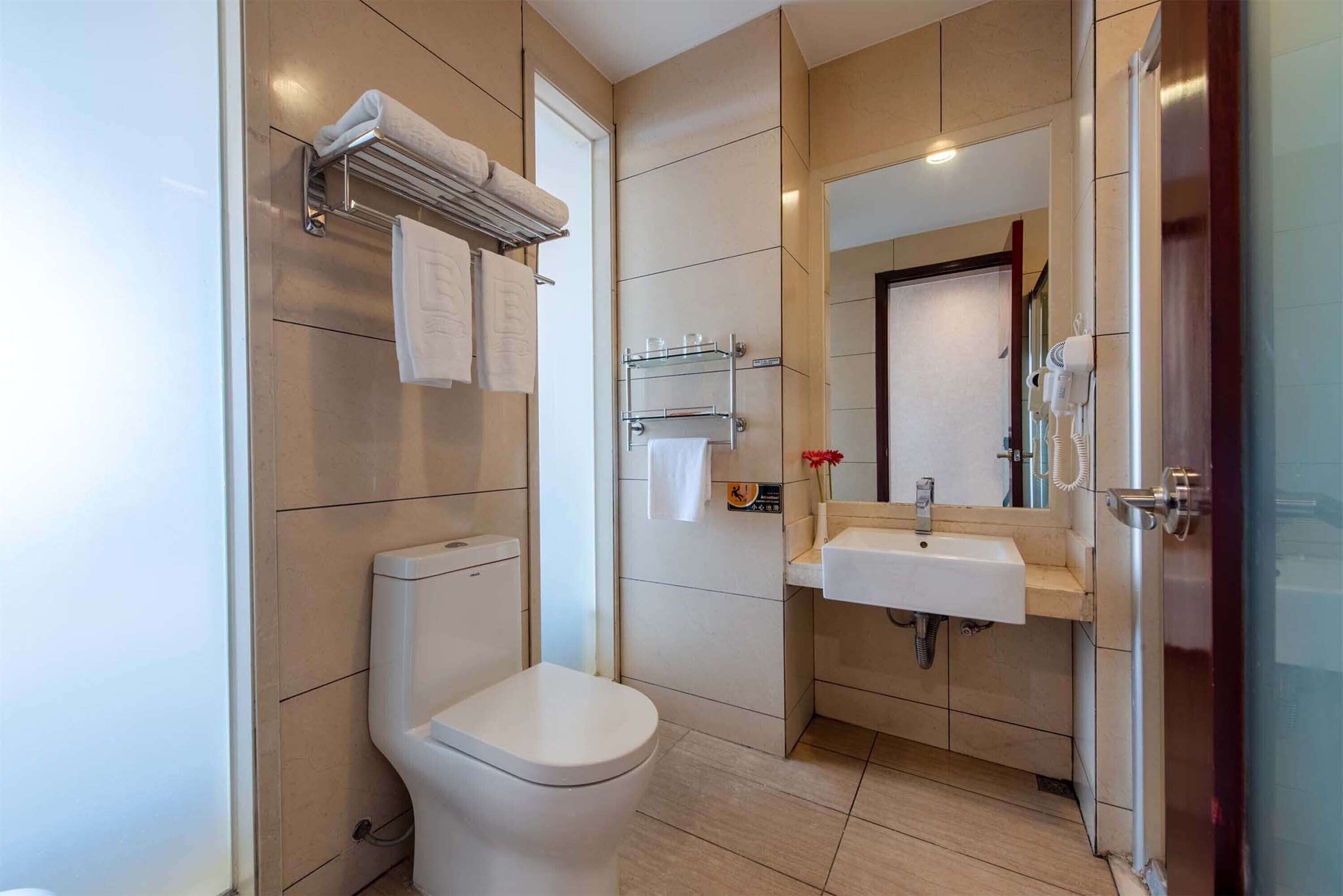 A modern bathroom with a toilet, a sink, and a shower area.