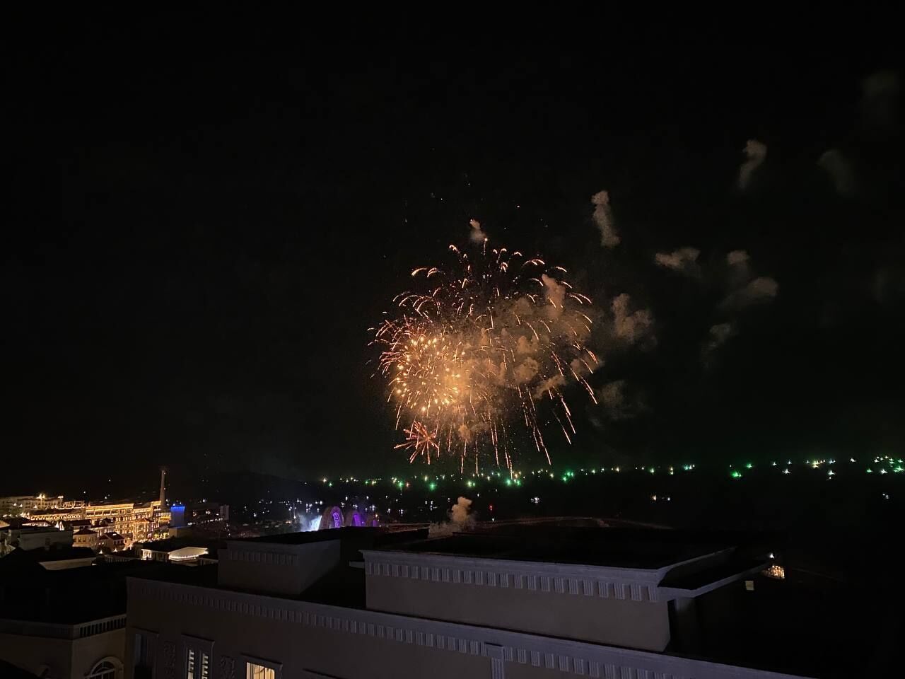 A nighttime view of a cityscape with fireworks in the sky.