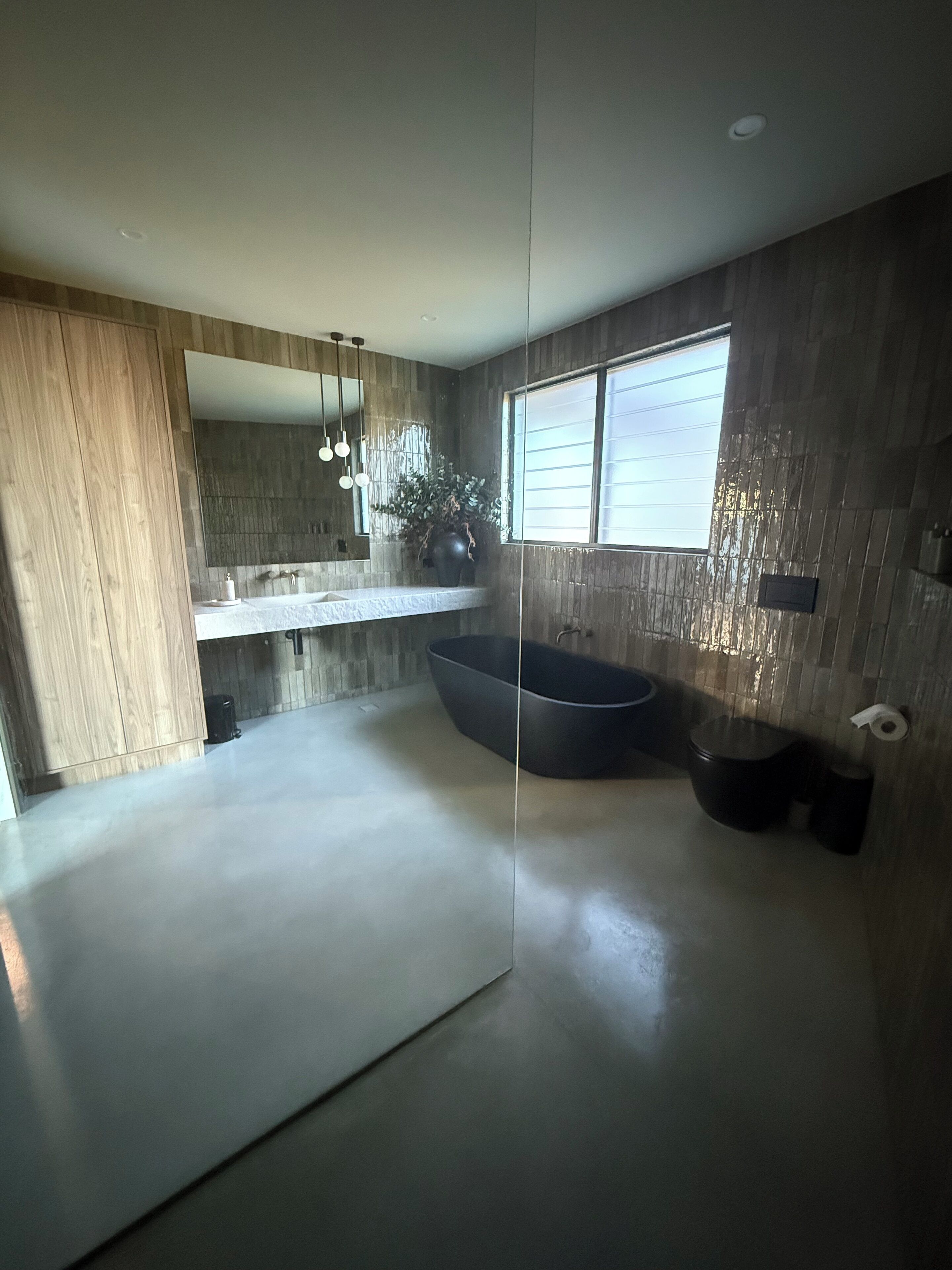 A modern bathroom with a large bathtub, a glass shower enclosure, and a large mirror.