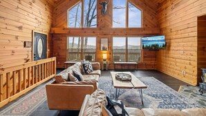 Une cabane en bois spacieuse, dotée d’un grand salon, d’une cheminée et offrant une vue magnifique sur les montagnes.