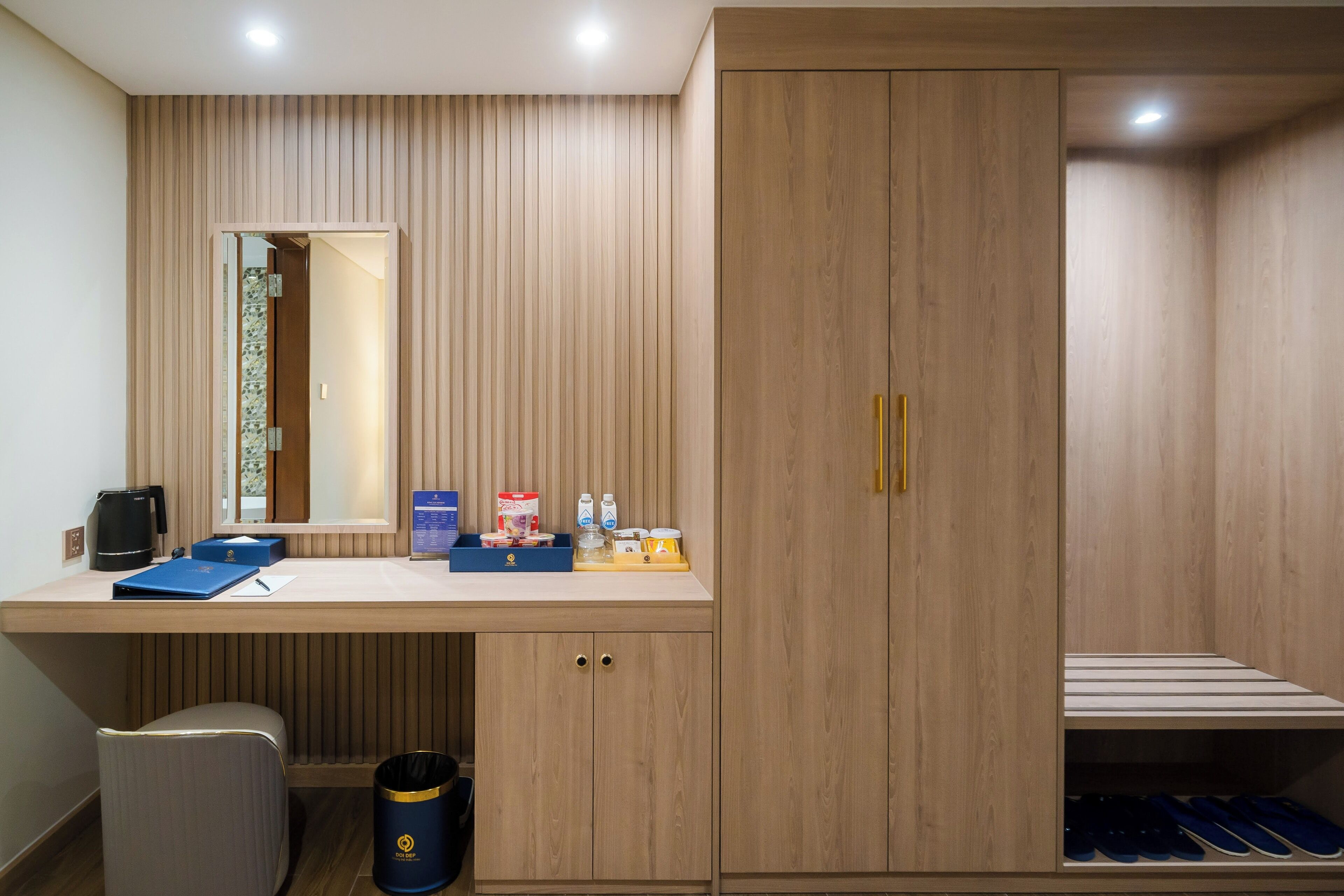 A modern bathroom with a wooden vanity, a mirror, and a built-in shoe rack.