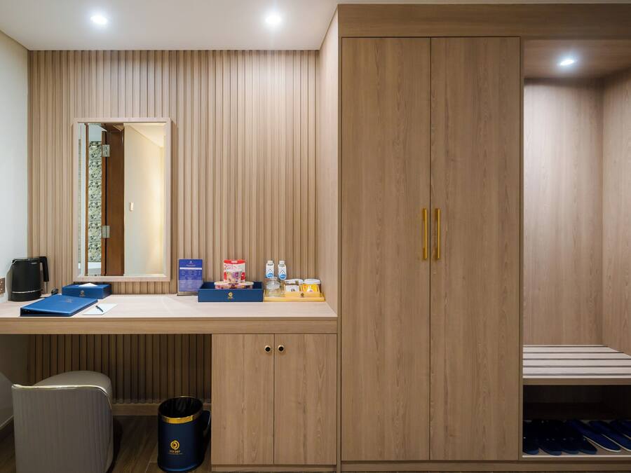 A modern bathroom with a wooden vanity, a mirror, and a built-in shoe rack.