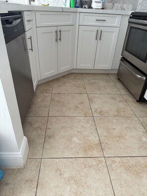 A kitchen with white cabinets, a dishwasher, and a stainless steel oven. - This is a two bed and two bath. Spacious Master Suite Near Hard Rock & Sawgrass. (Plantation)