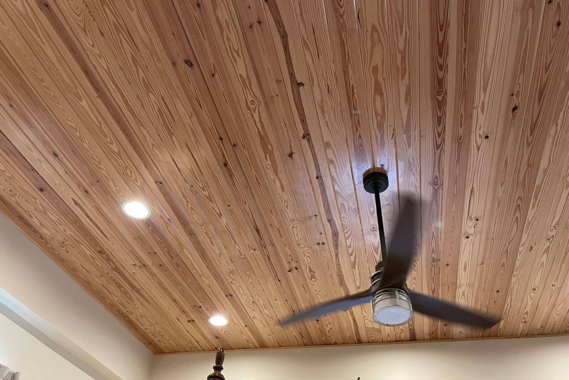 Una habitación con techo de madera y ventilador de techo.