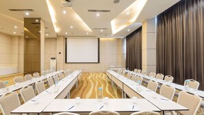 A conference room with a long table, chairs, a projector screen, and a large screen. - Artotel Harmoni Jakarta (Jakarta)