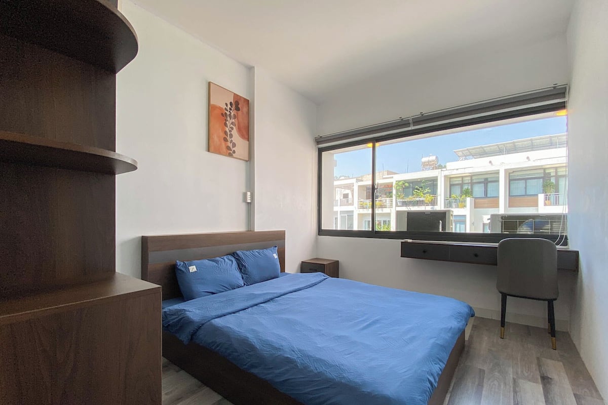 Ein Schlafzimmer mit Bett, Schreibtisch und Stuhl.