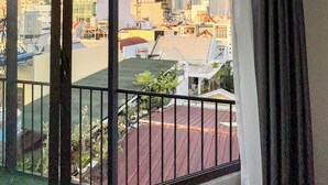 A balcony with a view of a cityscape, including a prominent skyscraper. - Zeus Living - 7C Downtown By Feet (Ho Chi Minh City)