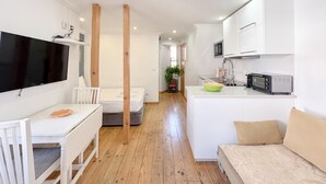 A compact living space with a kitchenette, a dining area, and a bedroom. - Comfort in the heart of Alfama (Lisboa)