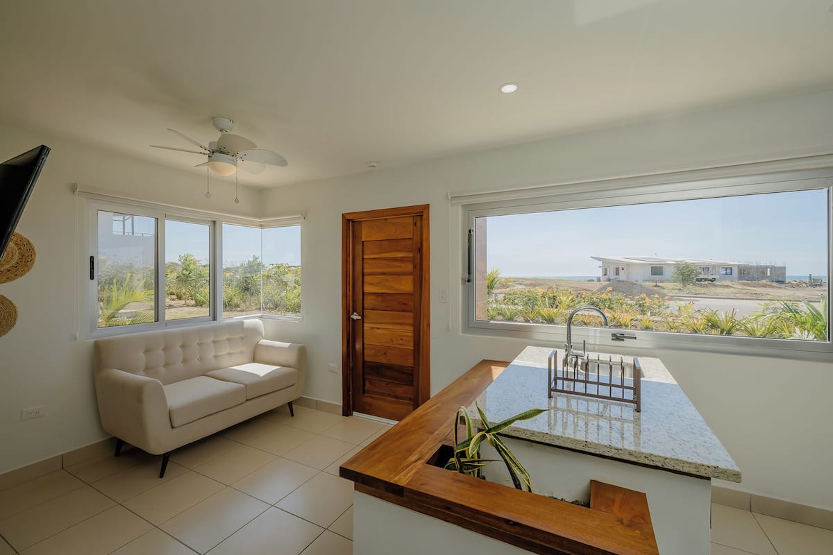 Signature House, 2 Bedrooms, Balcony | Living room | 40-inch Smart TV with cable channels