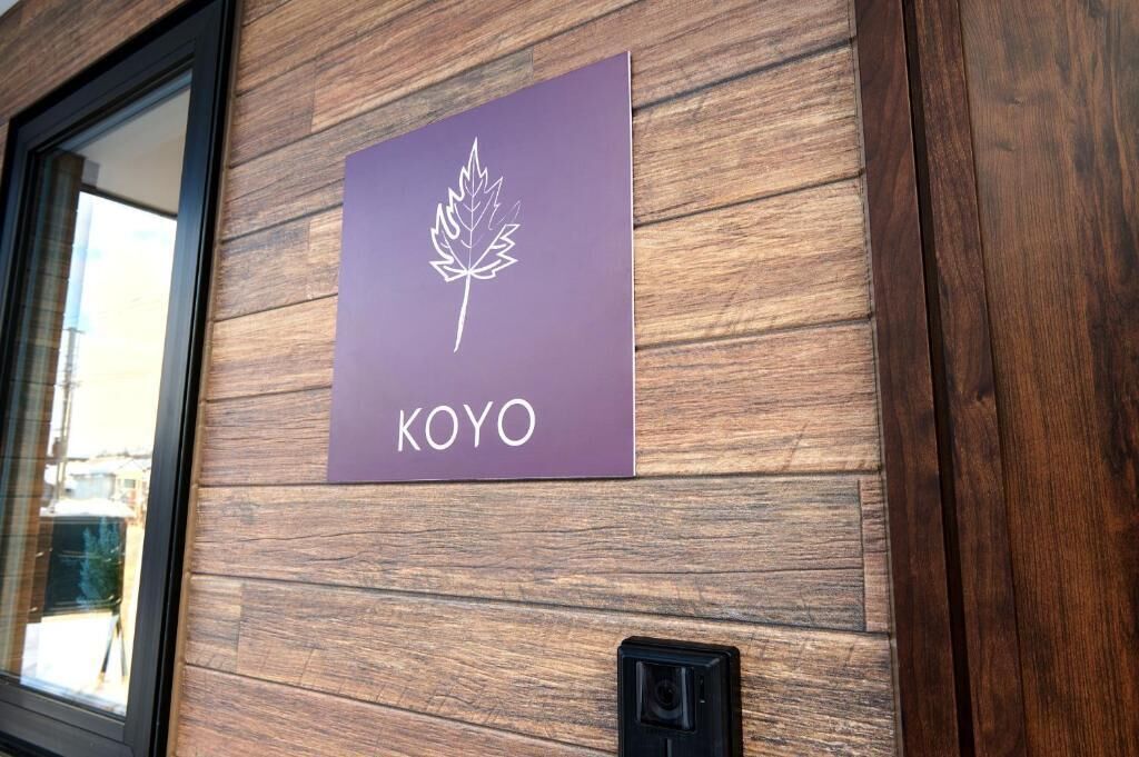 A wooden wall with a purple sign that reads "KOYO".