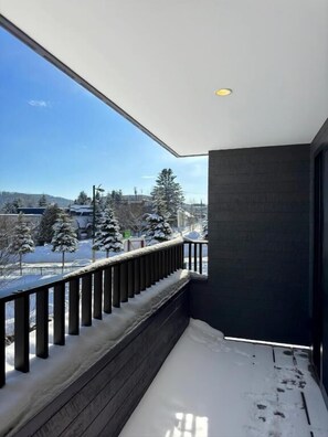 A balcony with a view of a snowy landscape and trees. - KOYO YUKI (Furano)