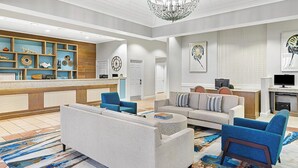 A modern lobby with a reception desk, seating area, and artwork on the walls.