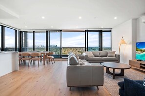 A spacious living area with a city view, a dining table, and a sofa.