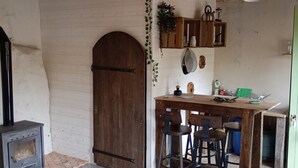 A rustic kitchen with a wooden table, bar stools, and a built-in oven.