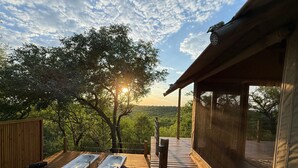 A wooden deck with two hot tubs, a wooden fence, and a view of a forested landscape. - Bushveld Bivouac Private Camp (Mica)