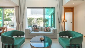 Un salon moderne avec un canapé, deux fauteuils et une table basse.