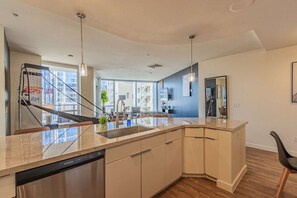 A modern kitchen with a dishwasher, a sink, and a built-in stove.