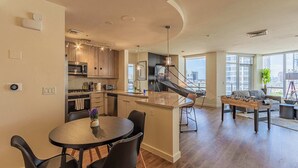 A modern apartment with a kitchen, dining area, and living room.
