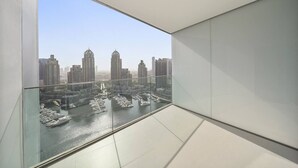 A modern interior with a large glass window offering a view of a marina and high-rise buildings.