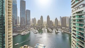 A marina with multiple boats docked, surrounded by high-rise buildings with modern architecture.