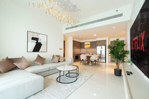 Departamento Deluxe, vista al mar | Área de sala de estar | Televisión de pantalla plana de 125 cm con canales digitales y Netflix