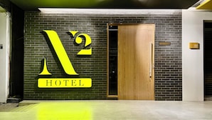 Entrada de un hotel con un cartel grande que muestra el número '2' y la palabra 'HOTEL'.