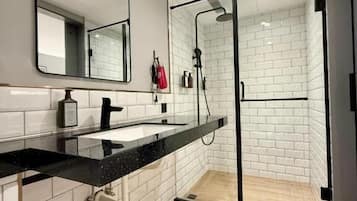 Habitación cuádruple Confort, vista a la ciudad | Baño | Regadera, secadora de cabello, pantuflas, toallas