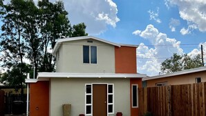 A two-story house with a front door, a small porch, and a wooden fence. - Modern New Mexico Loft in the heart of Las Cruces. (Las Cruces)