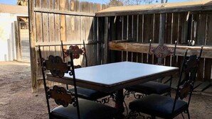 Eine Terrasse im Freien mit einem Holztisch und Metallstühlen.